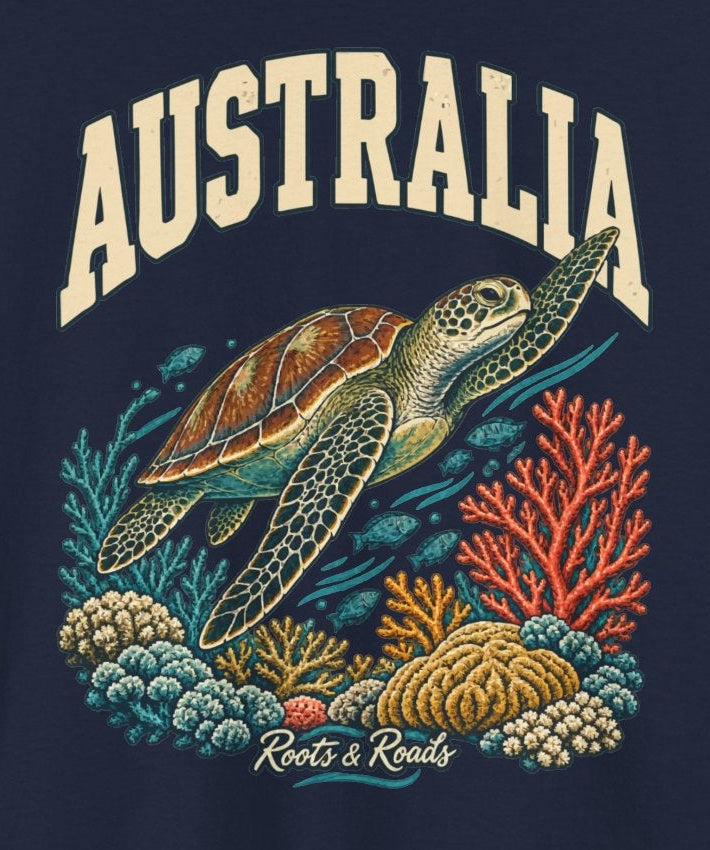Print detail on Navy cotton showing cream AUSTRALIA lettering above a sea turtle, teal and coral reef details, small fish, and Roots & Roads script.