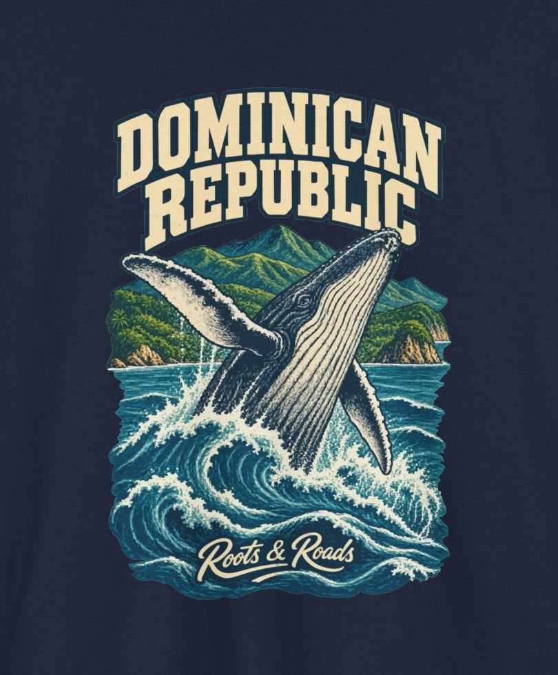 Print detail cropped from the Navy Dominican Republic supplier T-shirt mockup, showing cream two-line DOMINICAN REPUBLIC lettering, a breaching whale, blue waves and green coastal mountains and Roots & Roads script.