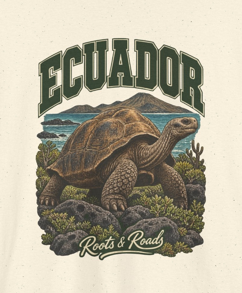Print detail cropped from the Natural Ecuador supplier T-shirt mockup, showing green ECUADOR lettering, a giant tortoise, volcanic rocks, low plants and coastal water and Roots & Roads script.