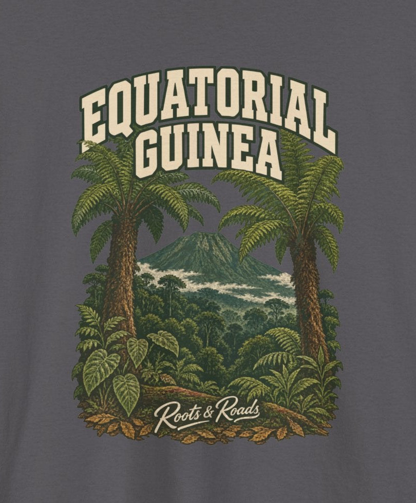 Print detail cropped from the Charcoal Equatorial Guinea supplier T-shirt mockup, showing cream two-line EQUATORIAL GUINEA lettering, tree ferns, a mountain summit and dense green forest and Roots & Roads script.