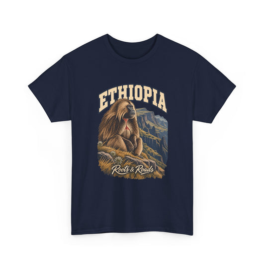 Front view of a Navy Gildan 5000 T-shirt with cream ETHIOPIA lettering above a shaggy gelada, grasses and steep mountain escarpments, finished with Roots & Roads script.