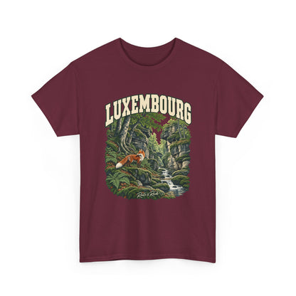 Front view of a Maroon Gildan 5000 T-shirt with cream LUXEMBOURG lettering, a red fox, mossy rocks, woodland roots, ferns and a flowing stream, and Roots & Roads script.