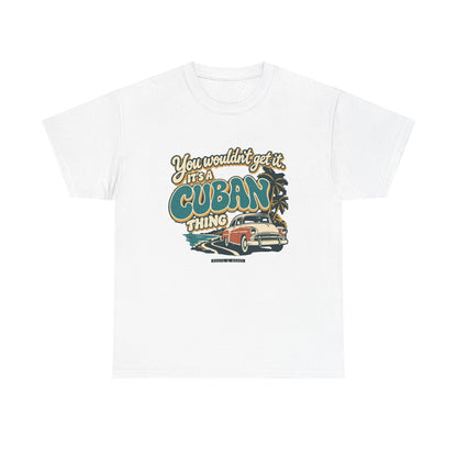 Front view of the White Cuban Thing T-shirt with “You wouldn’t get it. It’s a Cuban thing.” oversized teal rounded lettering with cream outlines and ochre shadows, a vintage coral car, coastal road and palm trees.