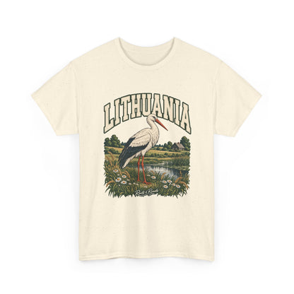 Front view of a Natural Gildan 5000 T-shirt with cream LITHUANIA lettering with a green outline, a white stork, a wet meadow, daisies, grain and a distant farmhouse, and Roots & Roads script.