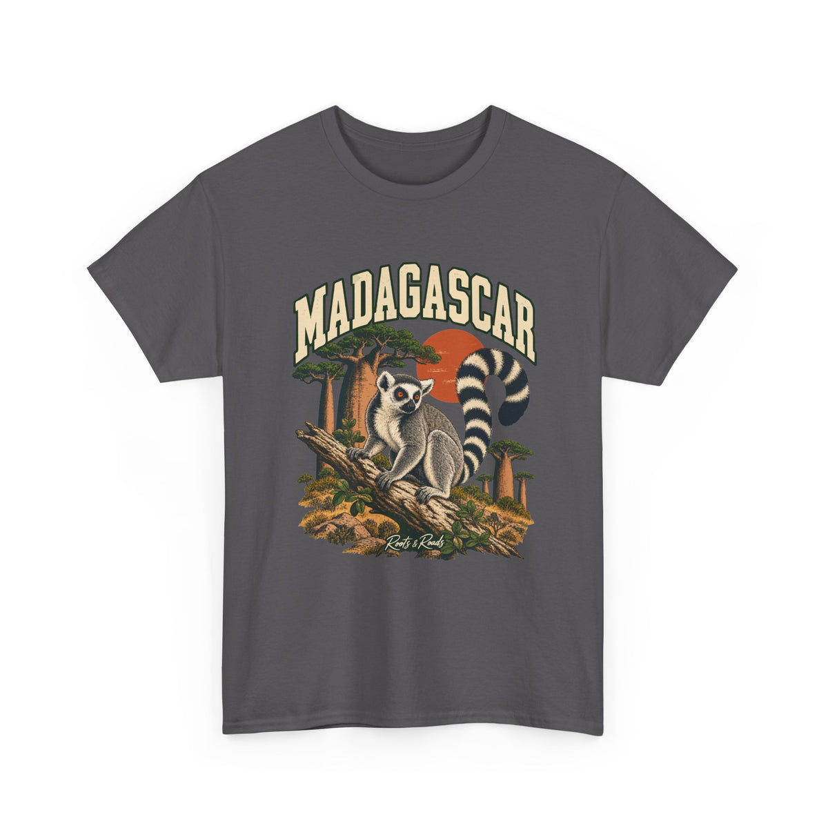 Front view of a Charcoal Gildan 5000 T-shirt with cream MADAGASCAR lettering, a ring-tailed lemur, a branch, baobab trees and a rust-coloured sun, and Roots & Roads script.