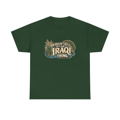 Forest Green Iraq Iraqi Thing T-shirt, flat front view with oversized cream lettering, marsh reeds, palm fronds and flowing blue water; “You wouldn’t get it. It’s an Iraqi thing.”