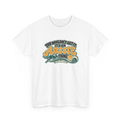 Alternate front view of the White Aussie Thing T-shirt with “You wouldn’t get it. It’s an Aussie thing.” gold bubble lettering, cream contours, a kangaroo, curling wave and sunset.