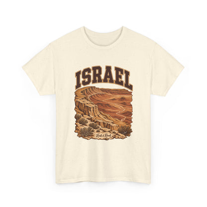 Front view of a Natural Gildan 5000 T-shirt with dark-brown ISRAEL lettering, layered ochre cliffs, dry channels and desert shrubs, and Roots & Roads script.