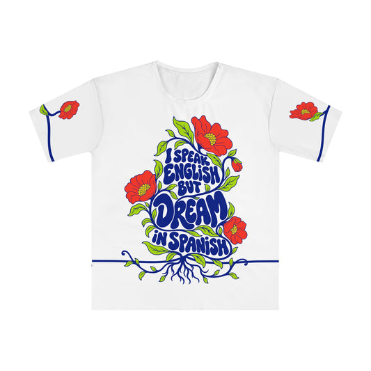 Front of the Roots & Roads “I speak English but dream in Spanish” T-shirt with cobalt lettering, coral flowers and lime foliage on white.