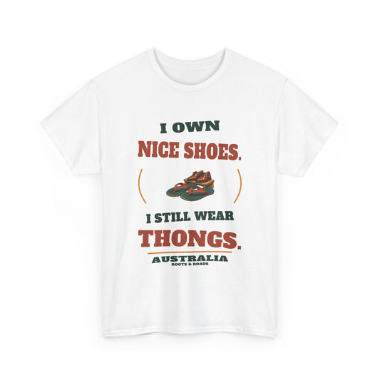 Australia Still Wear Thongs T-Shirt in White, with the full quote “I own nice shoes. I still wear thongs.”, Australia label, and Roots & Roads signature on the front.