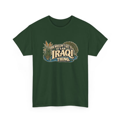 Forest Green Iraq Iraqi Thing T-shirt, shaped front view with oversized cream lettering, marsh reeds, palm fronds and flowing blue water; “You wouldn’t get it. It’s an Iraqi thing.”