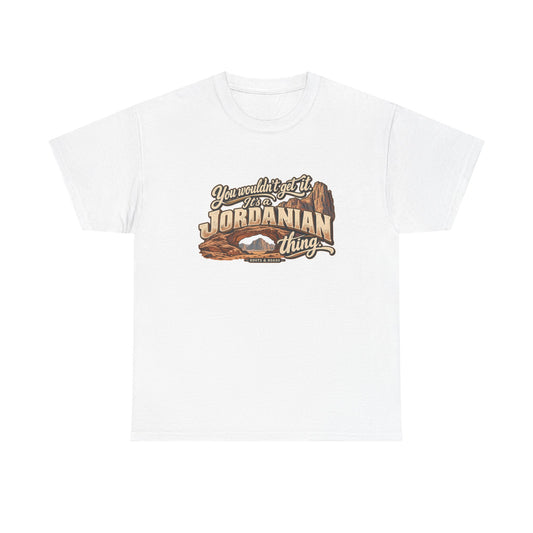 White Jordan Jordanian Thing T-shirt, flat front view with oversized cream lettering, sweeping script and sandstone arches and cliffs; “You wouldn’t get it. It’s a Jordanian thing.”