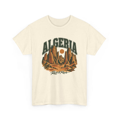 Front view of a Natural Gildan 5000 T-shirt with forest-green ALGERIA lettering, ochre sandstone towers and dunes, a round sun, and Roots & Roads script.
