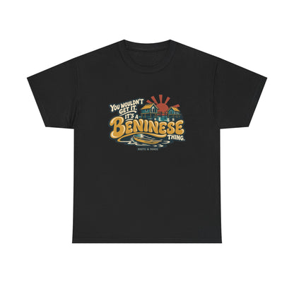 Front view of the Black Beninese Thing T-shirt with “You wouldn’t get it. It’s a Beninese thing.” gold bubble lettering with cream outlines, an integrated stilt village, canoe and sunset.
