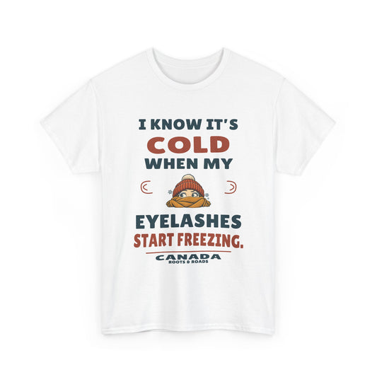 Canada Freezing Eyelashes T-Shirt in White, front winter hat and scarf illustration with the quote “I know it’s cold when my eyelashes start freezing.”
