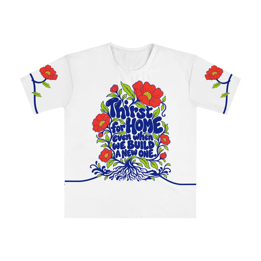 Front of the Roots & Roads “Thirst for home even when we build a new one.” T-shirt with cobalt lettering, coral flowers and buds, lime leaves and spreading roots on white.