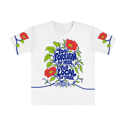 Front of the Roots & Roads “Too foreign for here, too local for there” T-shirt with cobalt bubble lettering, coral flowers, lime leaves and roots on white.