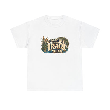 White Iraq Iraqi Thing T-shirt, flat front view with oversized cream lettering, marsh reeds, palm fronds and flowing blue water; “You wouldn’t get it. It’s an Iraqi thing.”
