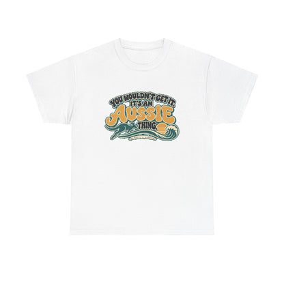 Front view of the White Aussie Thing T-shirt with “You wouldn’t get it. It’s an Aussie thing.” gold bubble lettering, cream contours, a kangaroo, curling wave and sunset.