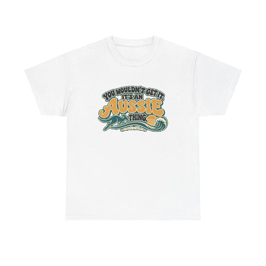 Front view of the White Aussie Thing T-shirt with “You wouldn’t get it. It’s an Aussie thing.” gold bubble lettering, cream contours, a kangaroo, curling wave and sunset.