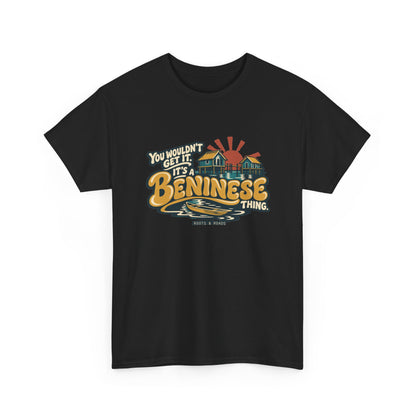 Alternate front view of the Black Beninese Thing T-shirt with “You wouldn’t get it. It’s a Beninese thing.” gold bubble lettering with cream outlines, an integrated stilt village, canoe and sunset.