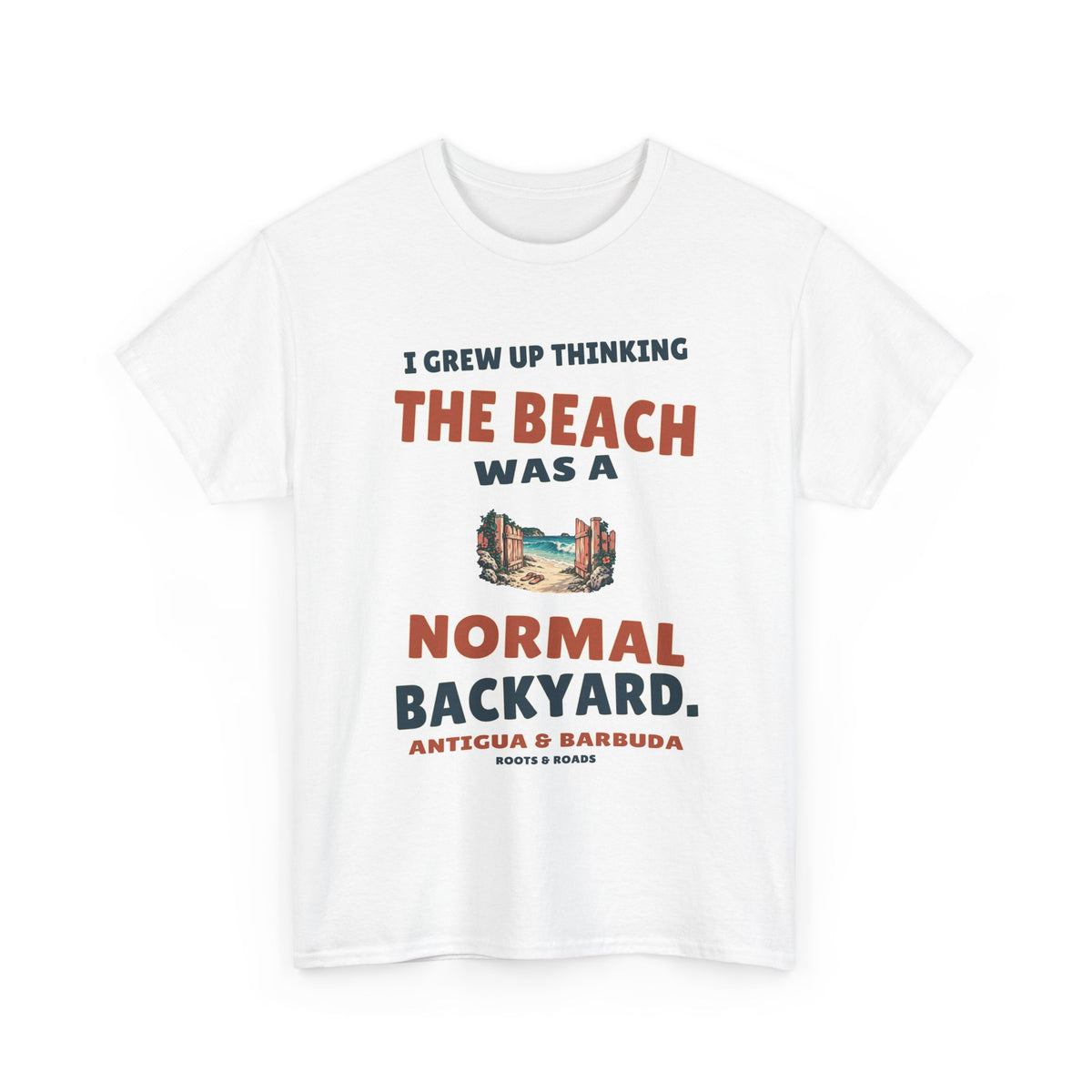 White Antigua & Barbuda T-shirt, front view with vintage artwork reading “I grew up thinking the beach was a normal backyard.” and Roots & Roads signature.