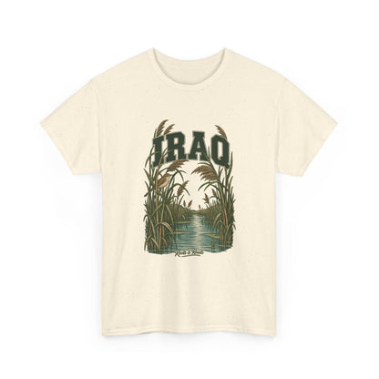 Front view of a Natural Gildan 5000 T-shirt with deep-green IRAQ lettering, a small bird, tall reeds and a quiet marsh channel, and Roots & Roads script.