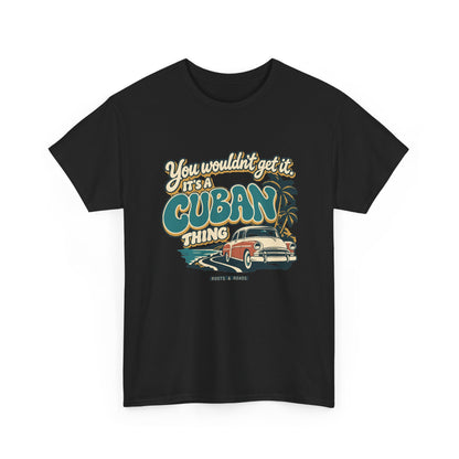 Alternate front view of the Black Cuban Thing T-shirt with “You wouldn’t get it. It’s a Cuban thing.” oversized teal rounded lettering with cream outlines and ochre shadows, a vintage coral car, coastal road and palm trees.