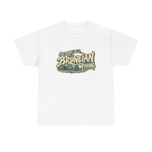 Front view of the White Bruneian Thing T-shirt with “You wouldn’t get it. It’s a Bruneian thing.” sweeping ivory lettering with gold shadows and integrated Kampong Ayer water-village houses and a footbridge.