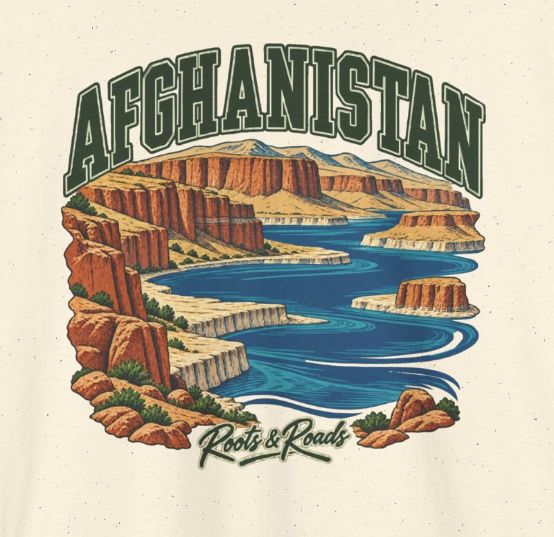 Close-up of Afghanistan Fresh Prints artwork on Natural cotton: forest-green lettering over blue highland lakes and rust-coloured cliffs, with Roots & Roads script.