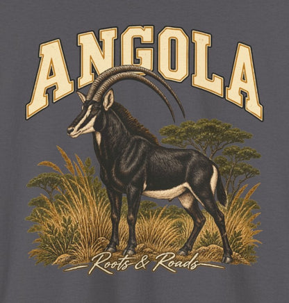 Print detail on Charcoal cotton showing cream ANGOLA lettering above a giant sable antelope, golden grasses, green trees, and the Roots & Roads script signature.