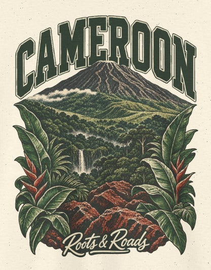 Print detail cropped from the Natural Cameroon supplier T-shirt mockup, showing green CAMEROON lettering above a forested volcano, waterfall, red rocks and broad tropical leaves and Roots & Roads script.