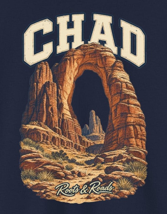Print detail cropped from the Navy Chad supplier T-shirt mockup, showing cream CHAD lettering above an ochre sandstone arch and desert rock pinnacles and Roots & Roads script.