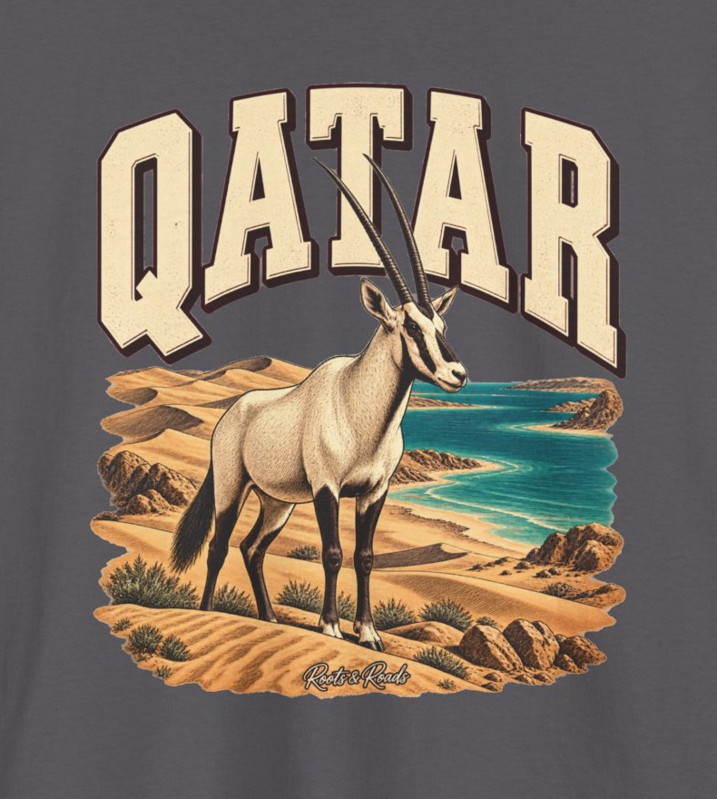 Print detail of QATAR lettering, Arabian oryx among golden dunes beside turquoise water, and original Roots & Roads script on Charcoal cotton.
