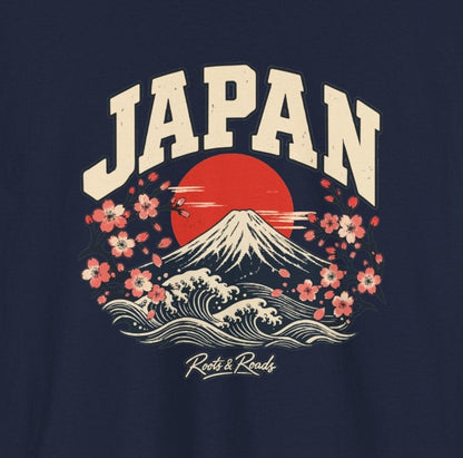 Close-up of the Japan Fresh Prints front design on navy cotton: cream arched lettering, Mount Fuji, a red sun, waves, cherry blossoms and Roots & Roads script.