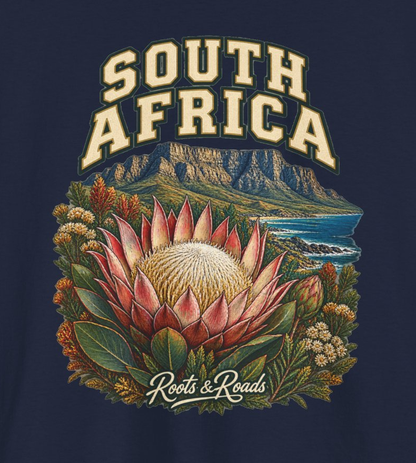 Close-up of the South Africa design showing cream lettering, a pink protea, a flat-topped coastal mountain, foliage and the Roots & Roads signature.