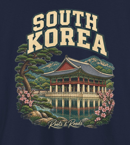 Close-up of the South Korea design with cream lettering, a pavilion reflected in water, pine branches, pink blossoms and the Roots & Roads signature.